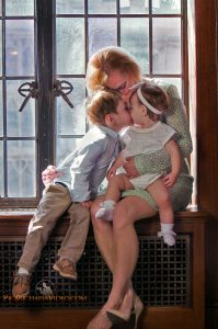 Little boy kisses baby sis in mother's day photo
